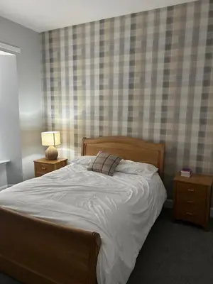 a bedroom with a large bed and two night stands at The Seaport Apartnment in Greenock