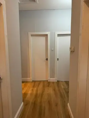 an empty room with two doors and wood floors at The Seaport Apartnment in Greenock