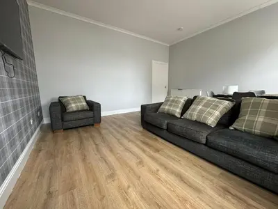 a living room with a couch and a chair at The Seaport Apartnment in Greenock