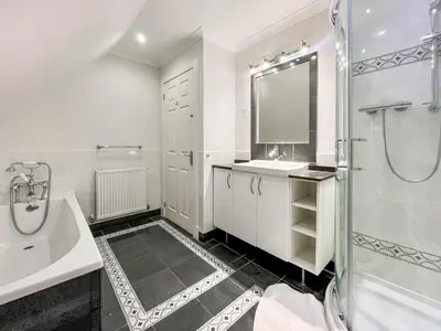 a white bathroom with a sink and a shower at Riverview Cottage in Kenmore