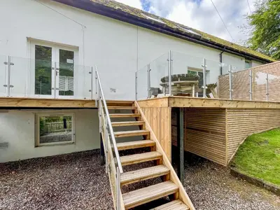 a house with a staircase leading up to a house at Riverview Cottage in Kenmore