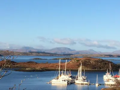 a group of boats docked in a body of water at Memorising sea views contemporary, spacious 4 bedroom coastal villa near Oban in Craobh Haven