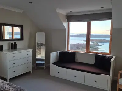 a bedroom with a bed and a large window at Memorising sea views contemporary, spacious 4 bedroom coastal villa near Oban in Craobh Haven
