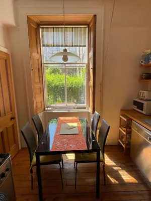a dining room table with chairs and a window at Charming flat in beautiful area in Edinburgh