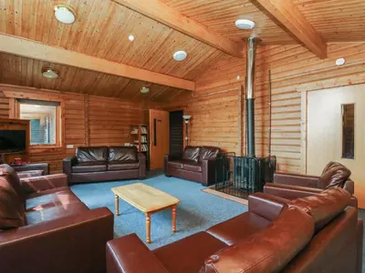 a living room with leather furniture and a fireplace at Shore Lodge Brodick Castle in Brodick