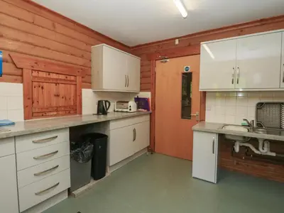 a kitchen with wooden walls and white cabinets at Shore Lodge Brodick Castle in Brodick