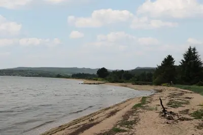 a sandy beach next to a body of water at Shore Lodge Brodick Castle in Brodick