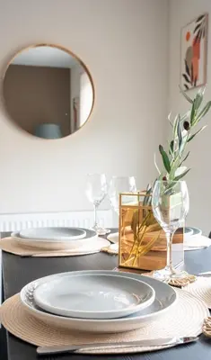 a table with plates and glasses and a mirror at Rise House in Livingston