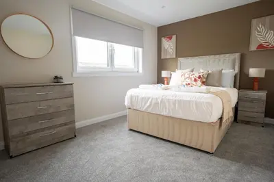 a bedroom with a bed with a mirror and a dresser at Rise House in Livingston
