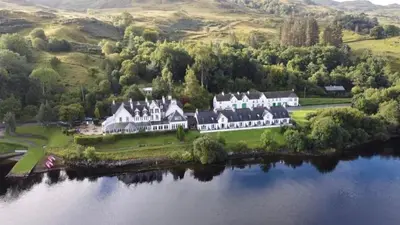 an aerial view of a large house on an island in a lake at Inveraray, Loch Awe Rooms and Apartments in Portsonachan