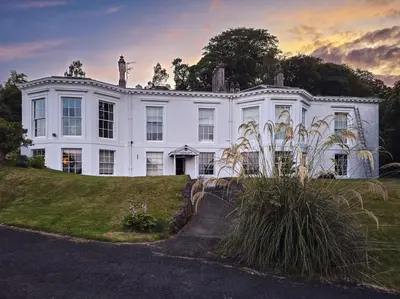 a large white house with a lawn in front of it at 2 Bed Flat - Sleeps 4 - Pets - Parking - Wifi in Rothesay