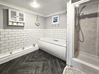 a bathroom with a bath tub and a shower at 2 Bed Flat - Sleeps 4 - Pets - Parking - Wifi in Rothesay