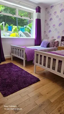 a bedroom with two beds and a purple rug at Jenny's Bay with Hot Tub in Lochgoilhead