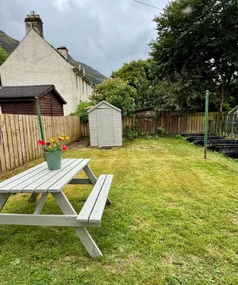 a picnic table sitting in the grass in a yard at West Highland Hideaway in Kinlochleven