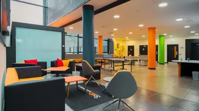 an office with tables and chairs and a projection screen at SOAB Residence in Hamilton