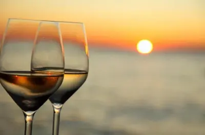 two glasses of wine with the sunset in the background at Sea view Villa Holiday and Corporate Let Accommodation in Prestwick