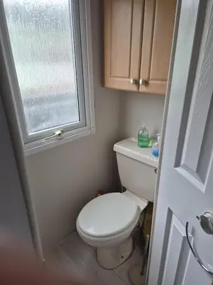 a small bathroom with a toilet and a window at Shep2 Caravans in Ballantrae