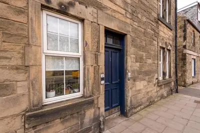 a brick building with a blue door and a window at Double Edinburgh Homestay in Edinburgh