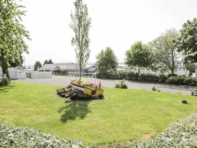 a park with a bench with flowers in the grass at Manor Heights Lodge in Wemyss Bay