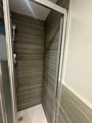 a shower with a glass door in a bathroom at Amazing Flat in London in Moffat