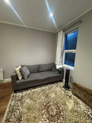a living room with a couch and a window at Amazing Flat in London in Moffat