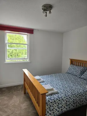 a bedroom with a bed and a window at Castle View Central Flat in Edinburgh