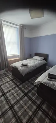 a bedroom with two beds and a window at 46 High Street in Campbeltown
