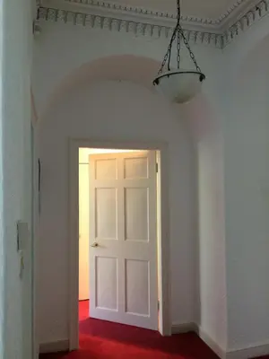 an empty room with a white door and a lamp at Limefield Mansion House in Livingston