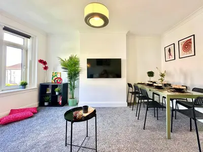 a living room with a dining room table and chairs at New quite and comfy home Glasgow in Knightswood