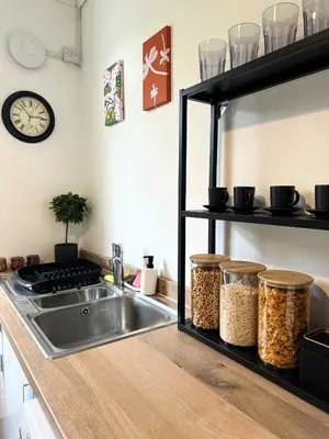 a kitchen with a sink and a shelf with food at New quite and comfy home Glasgow in Knightswood