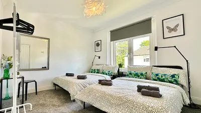 a bedroom with two beds and a window at New quite and comfy home Glasgow in Knightswood