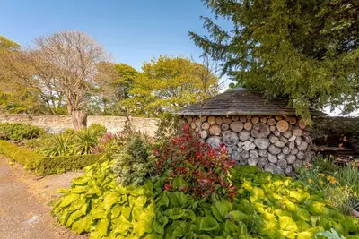 a garden with a pile of flowers and a stone building at Blossom Mansion in Edinburgh