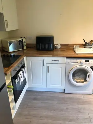 a kitchen with a washing machine and a microwave at 17 flat 11 slateford gait in Edinburgh