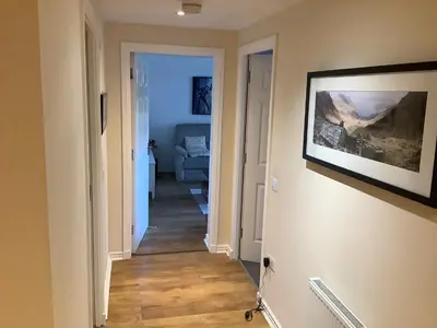 a hallway leading into a living room with a painting on the wall at 17 flat 11 slateford gait in Edinburgh