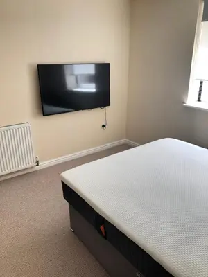 a bedroom with a bed and a flat screen tv on the wall at 17 flat 11 slateford gait in Edinburgh