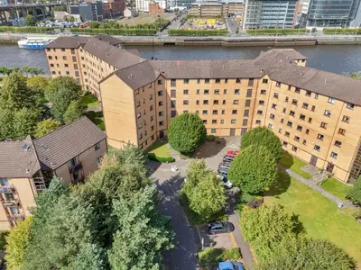 an overhead view of a building with trees and a river at Riverside City Apartment in Glasgow