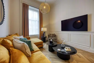 a living room with a couch and a tv at Luxury Refurbished City Retreat in Glasgow