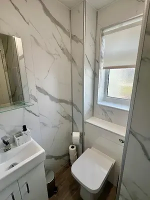 a white bathroom with a sink and a toilet at Newly refurbed 3 bed home 15mins to Edin city in Livingston