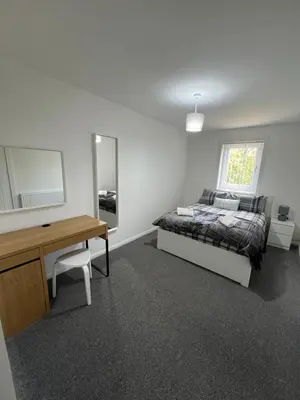 a bedroom with a bed and a desk and a mirror at Newly refurbed 3 bed home 15mins to Edin city in Livingston