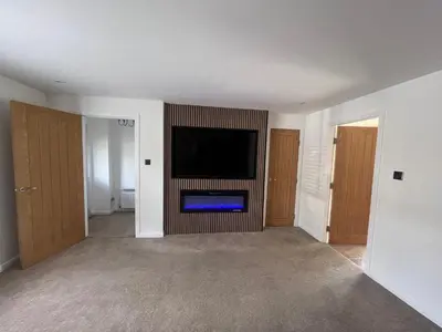 a living room with a flat screen tv on a wall at Bespoke home in Kirky in Kirknewton