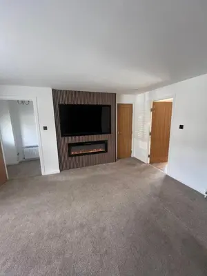 an empty living room with a flat screen tv at Bespoke home in Kirky in Kirknewton