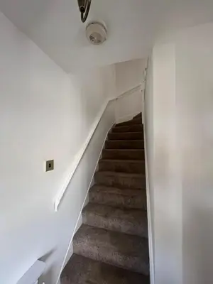 a staircase in a house with white walls at Bespoke home in Kirky in Kirknewton