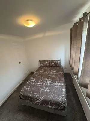 a bedroom with a bed in the corner of a room at Bespoke home in Kirky in Kirknewton
