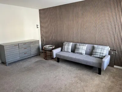a living room with a couch and a dresser at Bespoke home in Kirky in Kirknewton