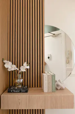 a shelf with a mirror and a vase with flowers at The Compact Caledonian Flat - Haymarket in Edinburgh