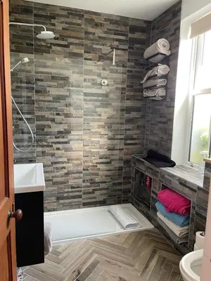 a bathroom with a shower with a glass door at Grey Gables Cottage, Brodick, Isle of Arran, Scotland in Isle of Arran