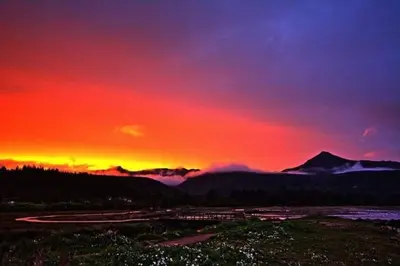 a sunset with a red and purple sky and mountains at Grey Gables Cottage, Brodick, Isle of Arran, Scotland in Isle of Arran