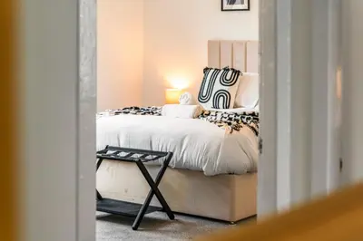 a bedroom with a bed and a table at Cosy and Bright 3-Bedroom Flat in Glasgow