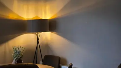 a room with a table and a lamp on a wall at ANSI Splendor in Livingston