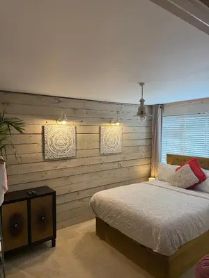a bedroom with a bed and a wooden wall at The Rookery in Moffat